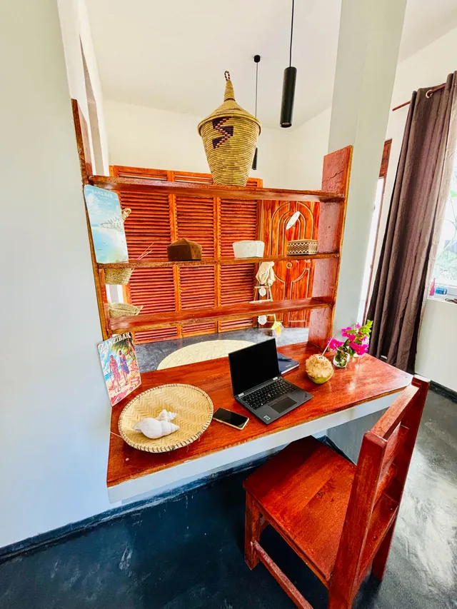 Schreibtisch mit Laptop und Holzregal im Doppelbungalow